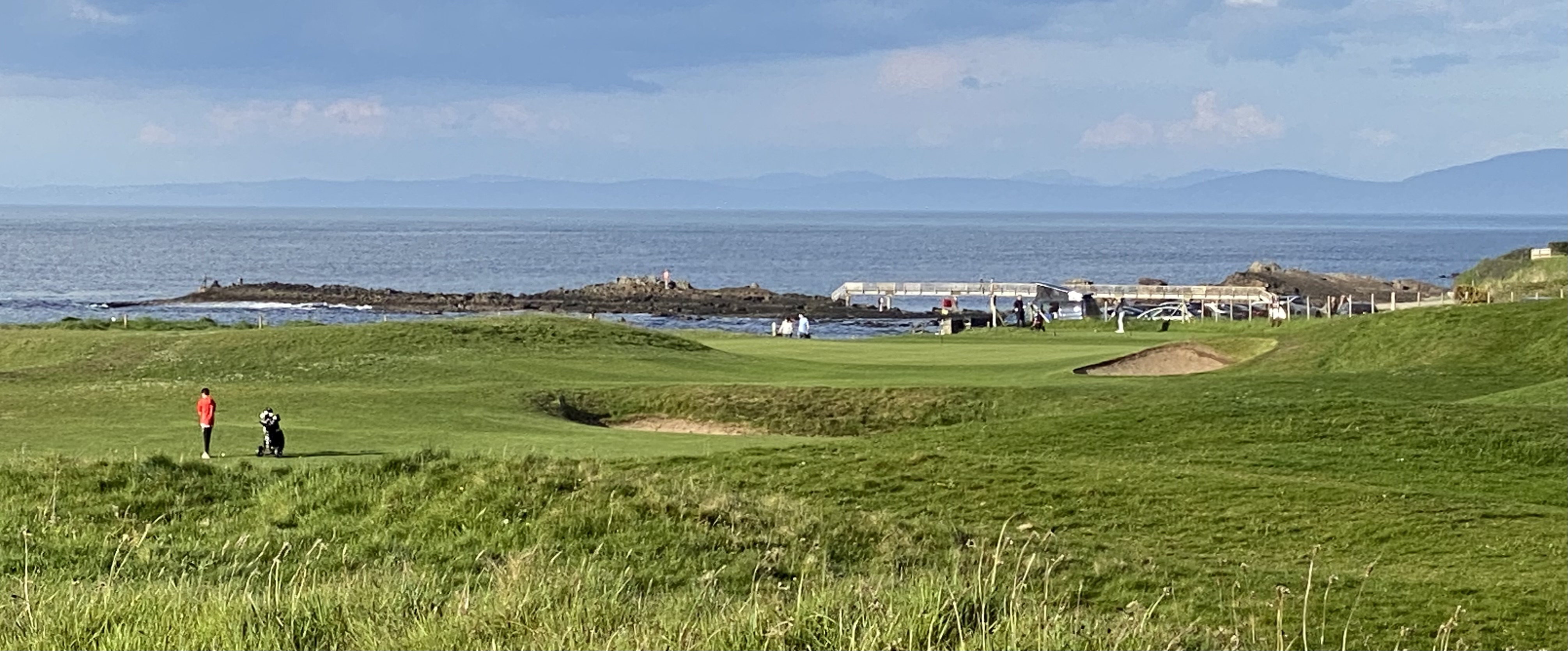 View of golf course with the sea in the distance 